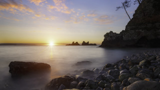 Sunset rocky beach lake mountain - a sunset over a rocky beach free wallpaper