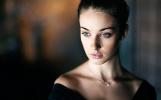 Serious woman necklace portrait blurry - her face and shoulder free wallpaper