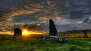 Sunset grassy field large rocks - a large rock formation in the foreground free wallpaper