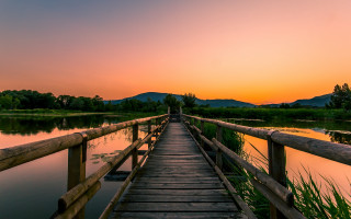 Wooden bridge mountain lake sunset - a mountain in the background and a lake in the foreground free wallpaper