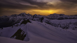 Snowy mountain dusk sunset ocean - snow under a cloudy sky free wallpaper