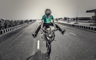 Motorcycle rider urban skyline trees - action pose free wallpaper