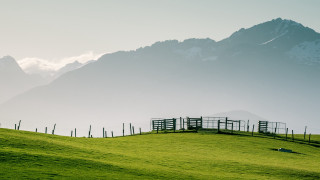 Grassy hill fence mountain clouds - a few sheep free wallpaper