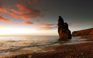 Rock formation beach sunset water 7 - a sunset in the background and a body of water free wallpaper