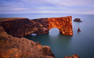 Rock formation bridge ocean mountain - a bridge in the middle of it free wallpaper