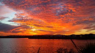 Sunset water clouds building horizon - a building in the distance free wallpaper
