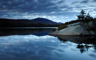 Lake rock mountain clouds sky 3 - a large rock in the middle of it free wallpaper