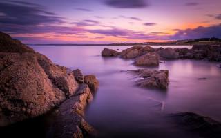 Sunset rocky beach lighthouse reflection - a long exposure of a sunset over a rocky beach free wallpaper