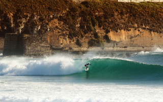 Surfer wave cliff beach city - anson maddock free wallpaper