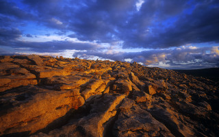 Rocky landscape cloudy sky dusk - dramatic light free wallpaper