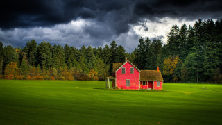 Red house field trees clouds - a dark sky in the background free wallpaper for desktop