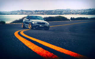 Car road city night ocean - side and a city in the background free wallpaper