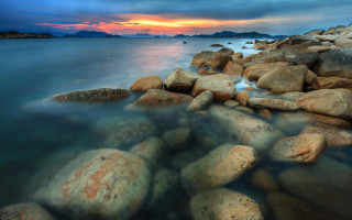 Rocky beach sunset water rocks - a sunset in the background and a body of water free wallpaper