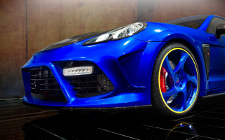 Blue sports car yellow rims 2 - a wooden wall behind free wallpaper