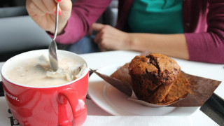Woman eating muffin coffee table - a woman in the background free wallpaper