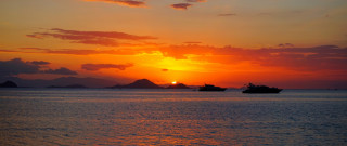 Sunset boats mountain dusk ocean - the water and a mountain in the distance free wallpaper