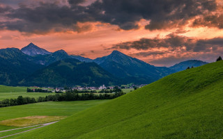 Green field mountain sunset cityscape - a mountain range in the background free wallpaper for desktop
