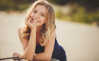 Woman smiling leaning on table - her chin free wallpaper for desktop