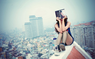 Rooftop cityscape woman reading iphone - city background free wallpaper
