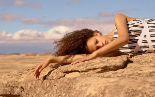 Woman rock stretching arm beach - a rock free wallpaper