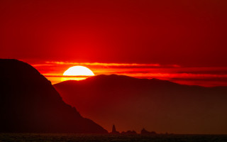 Sunset mountain red sky ocean - a red sky in the background free wallpaper