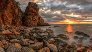 Rocky beach sunset surfboard mountains - the shore free wallpaper