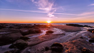 Sunset rocky beach water clouds 3 - a sunset over a rocky beach free wallpaper