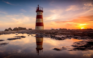 Lighthouse rocky beach sunset reflection - a rocky beach free wallpaper for desktop