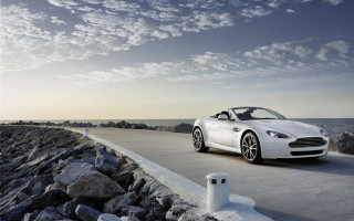 White sports car ocean rocks - a light pole free wallpaper