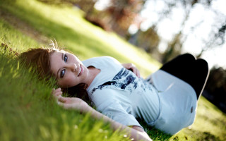 Woman laying in grass smiling - christabel dennison free wallpaper