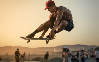 Skateboarder flying crowd beach sunset - fabien charuau free wallpaper