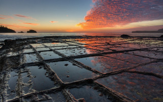 Sunset rocky beach water grid - a small island in the distance free wallpaper