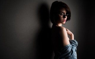 Woman glasses leaning wall portrait - against a wall free wallpaper