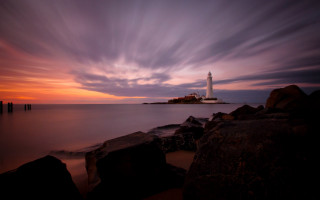 Lighthouse rocky shore sunset clouds 9 - andrew geddes free wallpaper