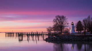 Lighthouse island sunset pink sky - a pier in the background free wallpaper