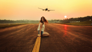 Woman sitting plane beach sunset - the ground in front free wallpaper