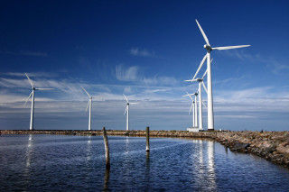Wind turbines water rocks sky - dirck van der lisse free wallpaper