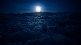 Snow covered field moonlight aurora - a bright light in the distance free wallpaper
