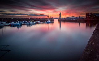 Harbor boats lighthouse sunset cloudy - under a cloudy sky free wallpaper