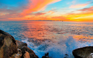 Sunset ocean boat rock outcropping - colorful cloud free wallpaper