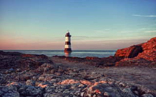 Lighthouse rocky shore sunset mountain - a rocky shore free wallpaper
