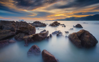 Mystical rocks sunset mountain reflection - a cloudy sky above them free wallpaper