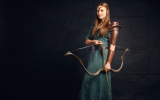 Woman green dress archer fantasy - a black background behind her free wallpaper