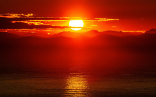 Sunset mountains water clouds red - a sunset over a body of water free wallpaper