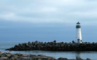 Lighthouse rocky pier precisionism cloudy - a lighthouse free wallpaper