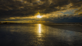 Sunset beach cityscape cloudy sky - dramatic light free wallpaper