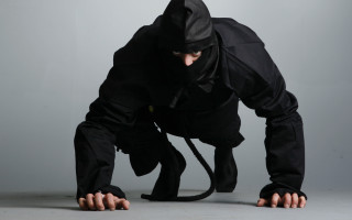 Man black outfit bending mask - a black mask free wallpaper