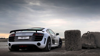 White sports car rock formation - a cloudy sky in the background free wallpaper