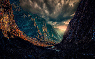 Mountain river cloudy sky sunset - a sunbeam in the distance free wallpaper