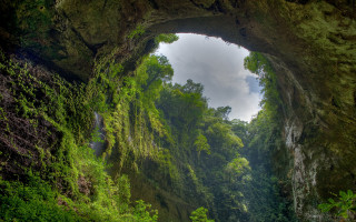 Cave waterfall forest greenery sky - a waterfall in the middle of it free wallpaper